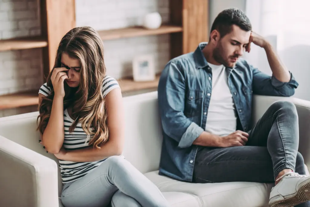 Paar sitzt distanziert auf dem Sofa und wirkt traurig – Sinnbild für Trennung trotz Liebe und Beziehungskrise